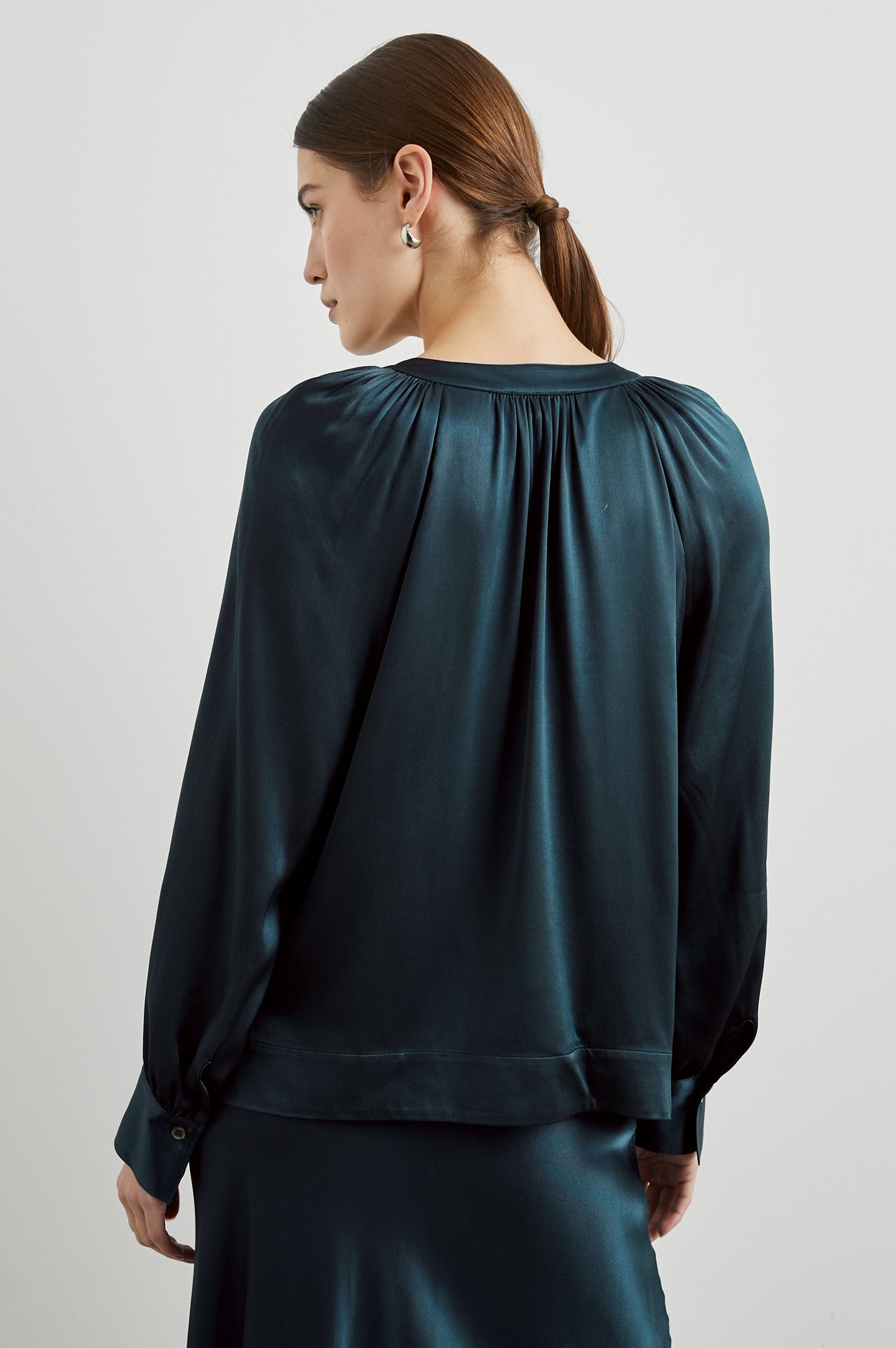 Wynna Long-Sleeve Top with a Deep V Neck and Ruching above the Cuffs and at the Neckline in Deep Sea Colorway - Back View Featured on Model