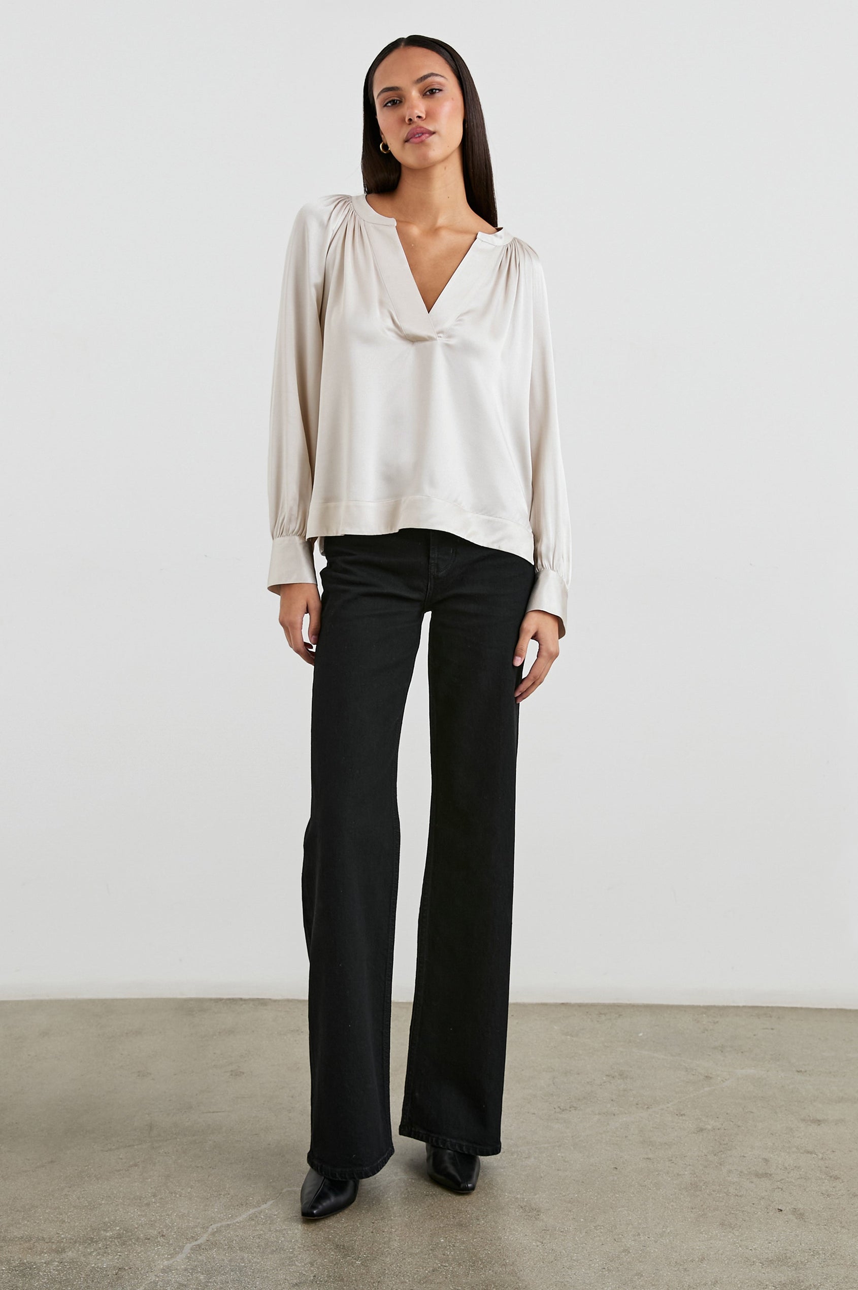 Wynna Long-Sleeve Top with a Deep V Neck and Ruching above the Cuffs and at the Neckline in Ivory Colorway - Front View Featured on Model