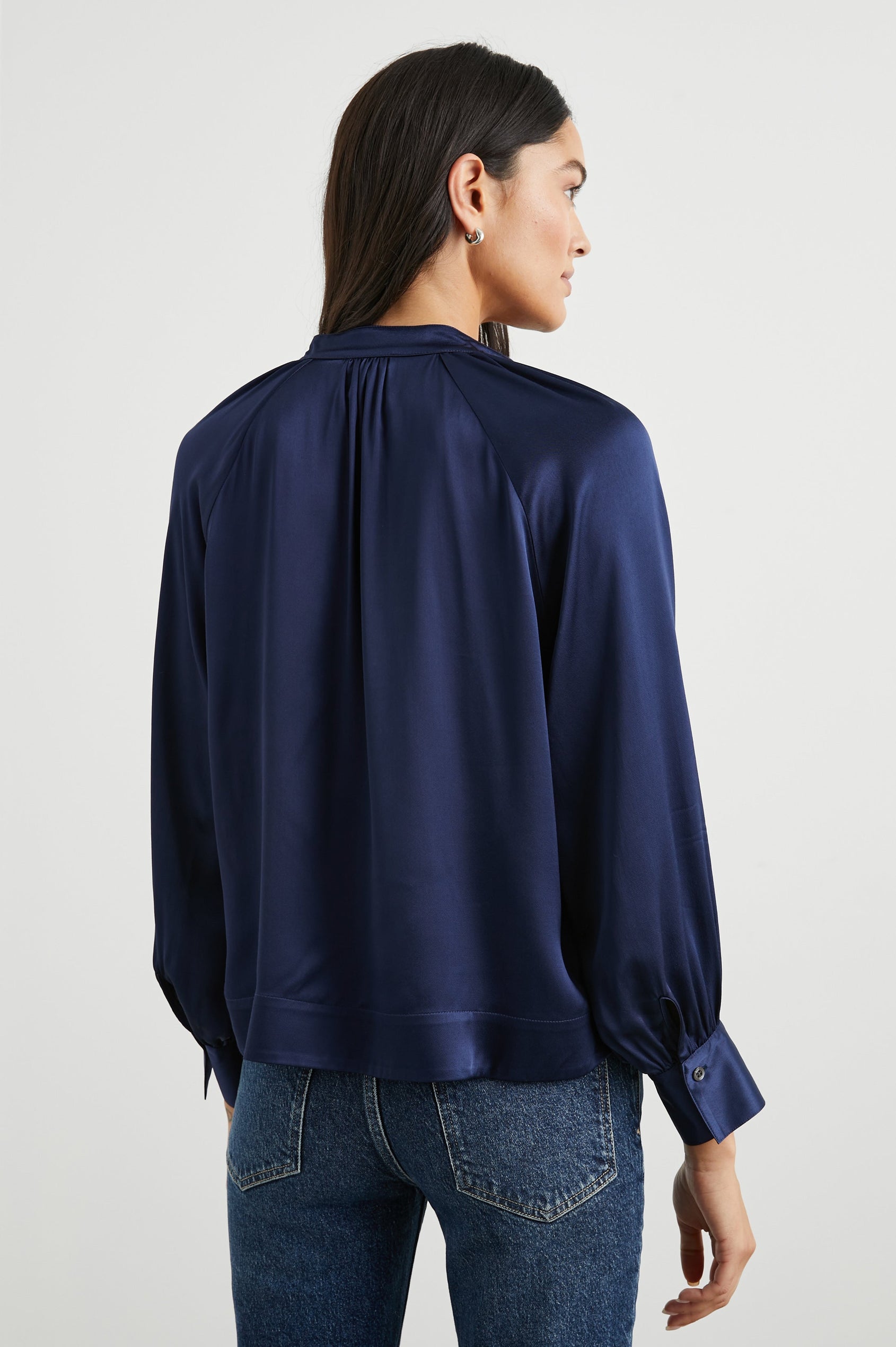 Wynna Long-Sleeve Top with a Deep V Neck and Ruching above the Cuffs and at the Neckline in Navy Colorway - Back View Featured on Model