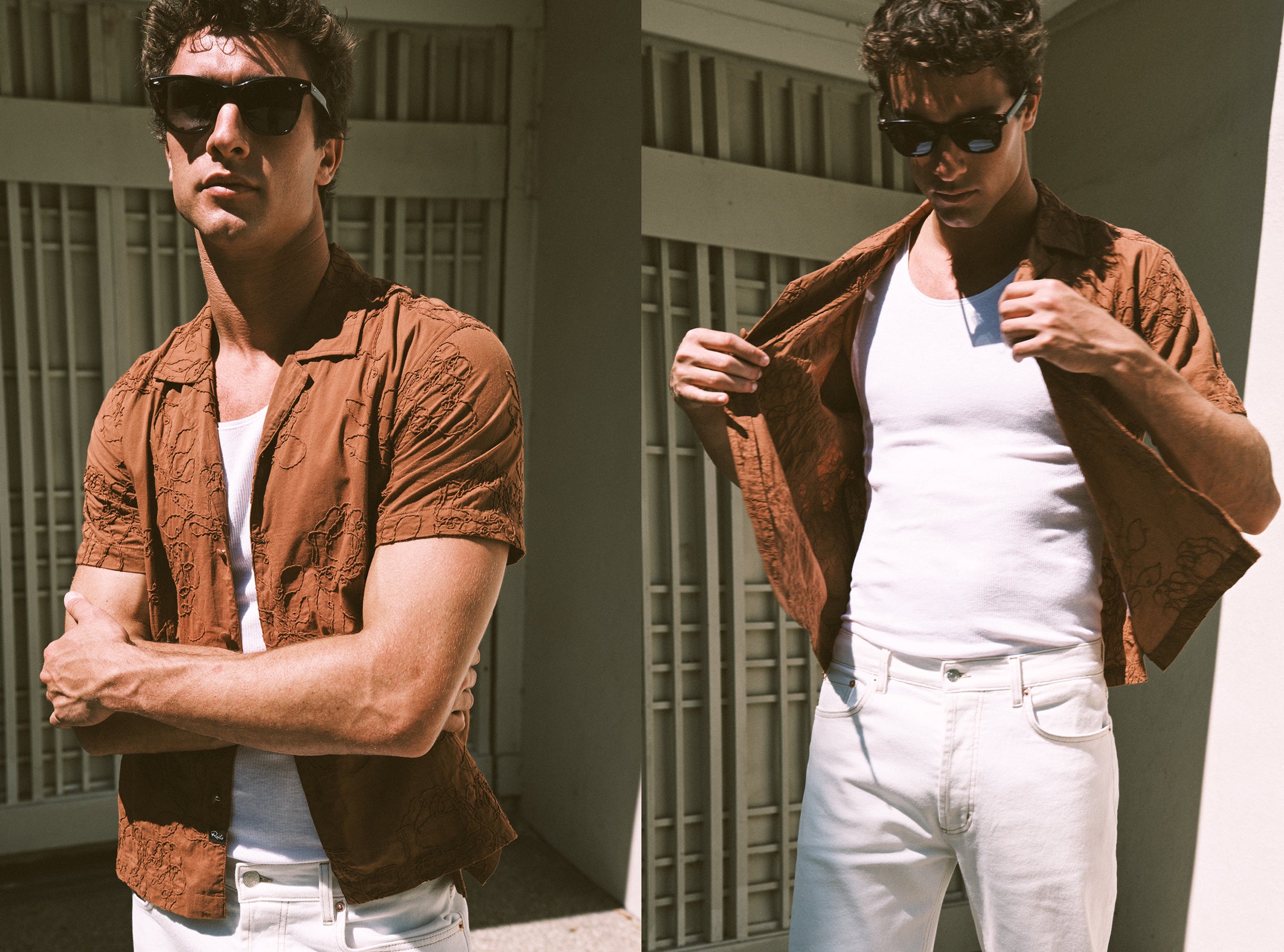 Man wearing a brown shirt over a white tank top and white pants, standing against a neutral background.