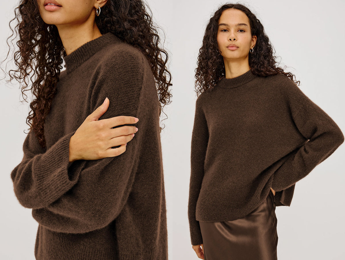 Woman wearing a brown cashmere sweater with a brown skirt against a white background.