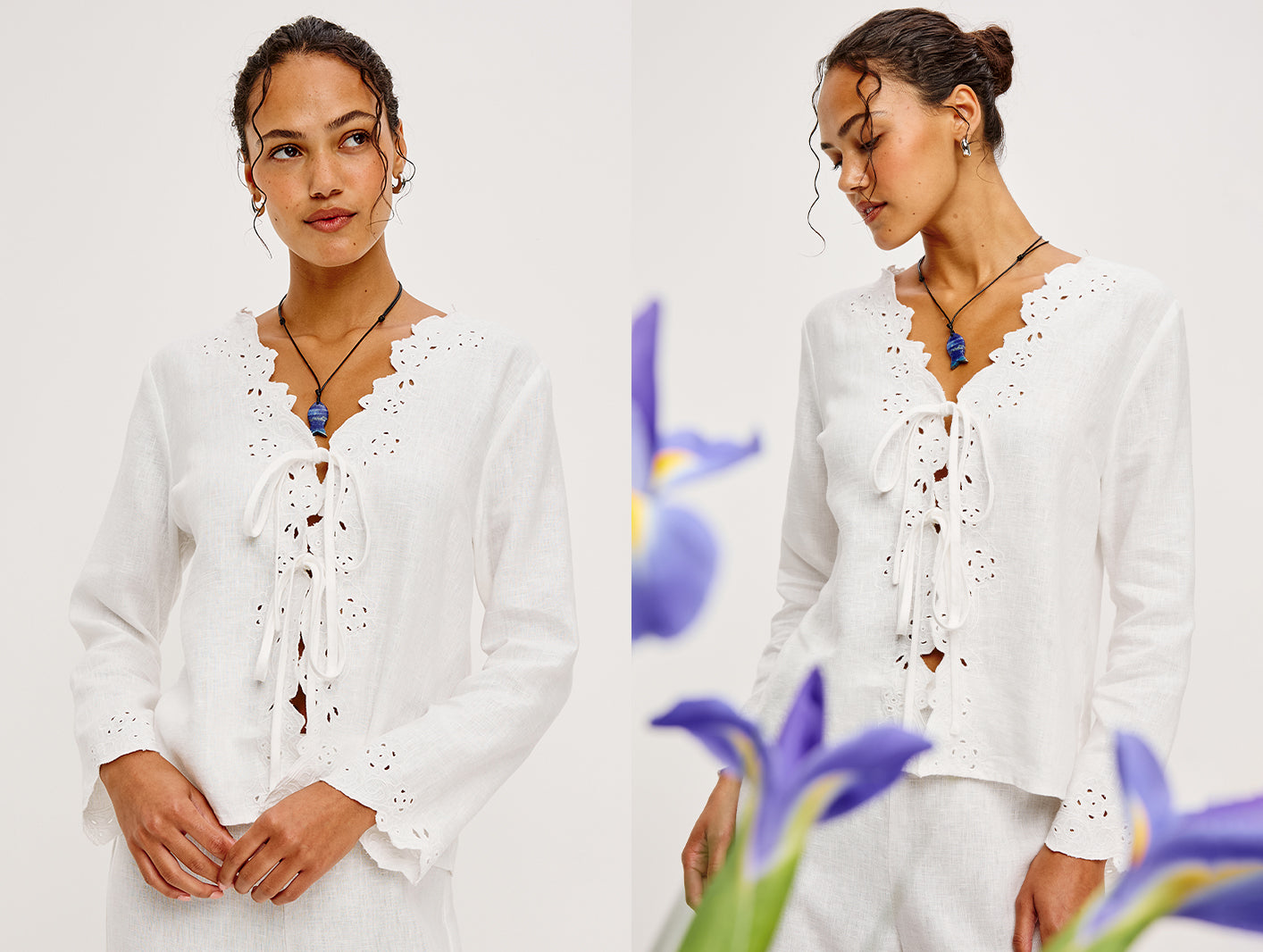 Woman wearing a white blouse with lace details, standing against a light background with flowers.