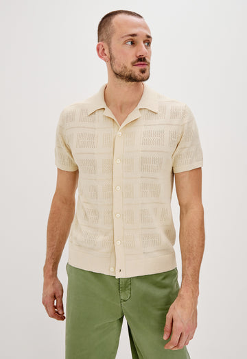 Yates Button Front Knit Shirt with Short Sleeves, a Relaxed Collar and Lapel, Ribbed Sleeve Cuff, Collar, Hem and Front Button Placket in Cream Colorway. Front View Shown on Model.