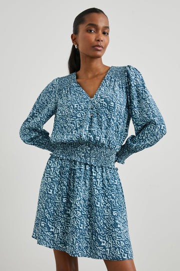 Zana Long-Sleeve Mini Dress with a V Neck, Smocked Cuffs and Waist, and Buttons Down the Bodice in Blue Havana Colorway, a Print in Blues - Front View Featured on Model