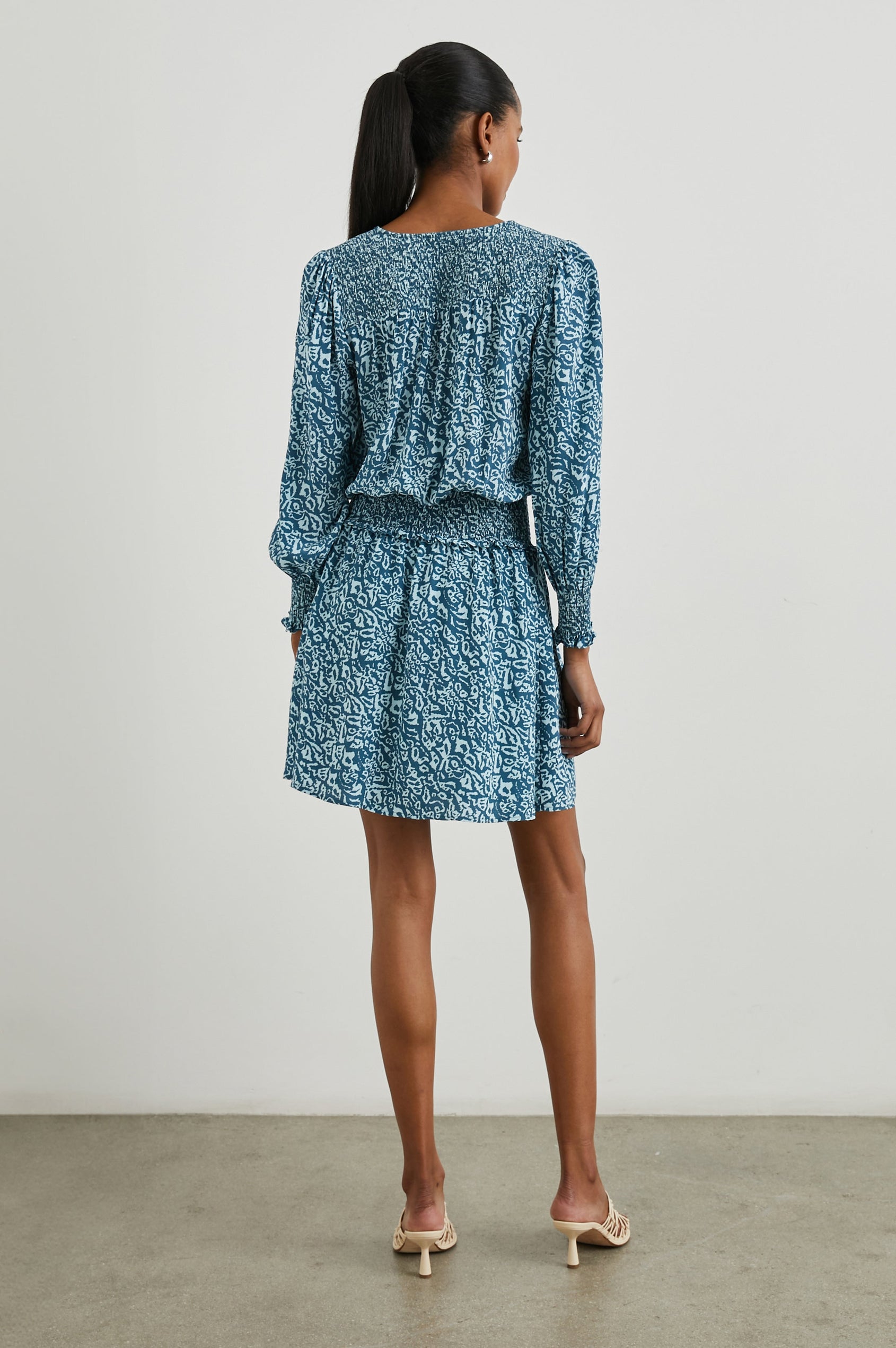 Zana Long-Sleeve Mini Dress with a V Neck, Smocked Cuffs and Waist, and Buttons Down the Bodice in Blue Havana Colorway, a Print in Blues - Back Full Body View Featured on Model