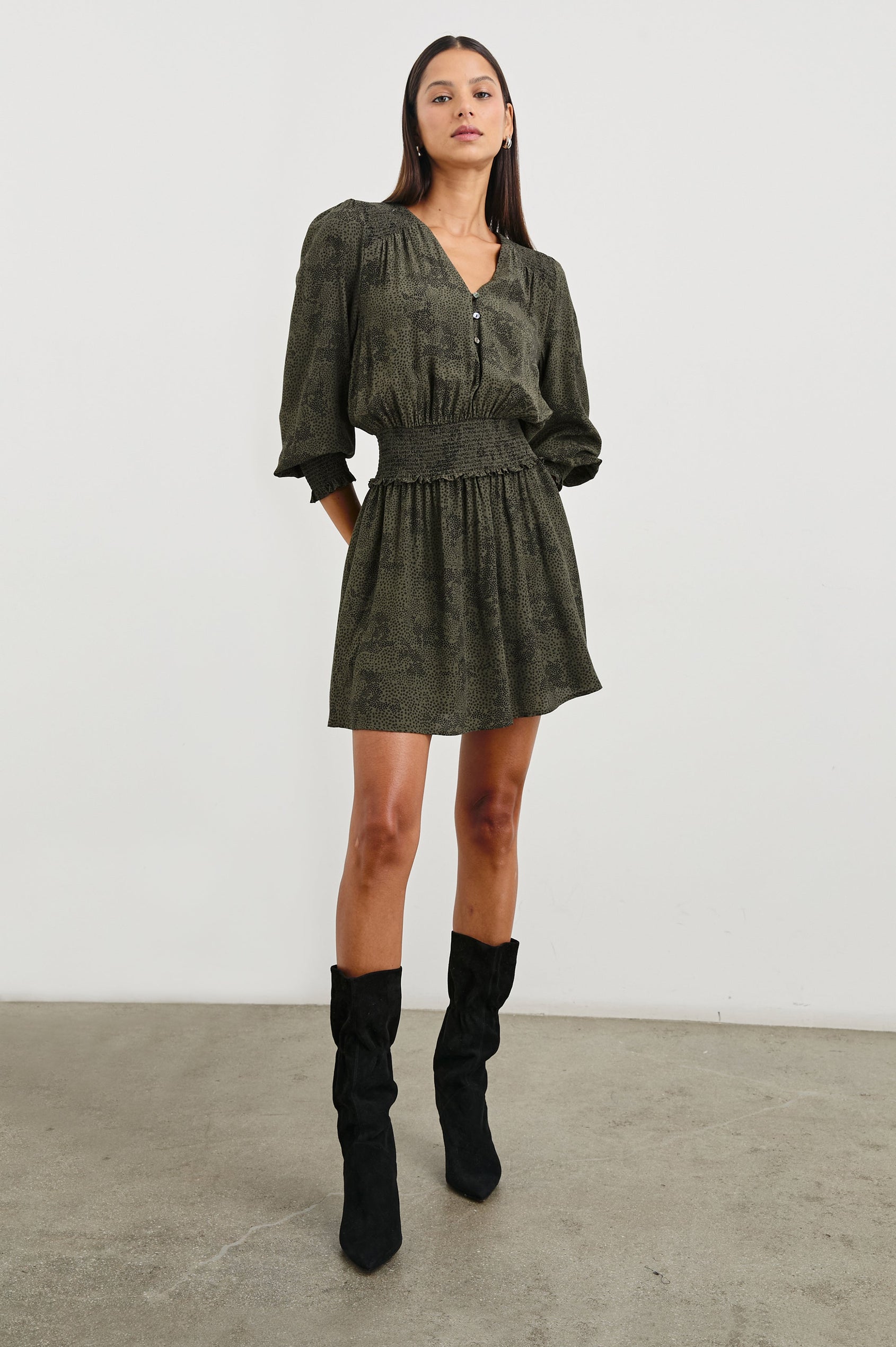 Zana Long-Sleeve Mini Dress with a V Neck, Smocked Cuffs and Waist, and Buttons Down the Bodice in Olive Pebble Colorway, an Olive and Black Pattern - Front Full Body View Featured on Model