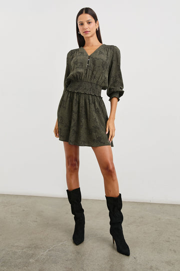 Zana Long-Sleeve Mini Dress with a V Neck, Smocked Cuffs and Waist, and Buttons Down the Bodice in Olive Pebble Colorway, an Olive and Black Pattern - Front Full Body View Featured on Model