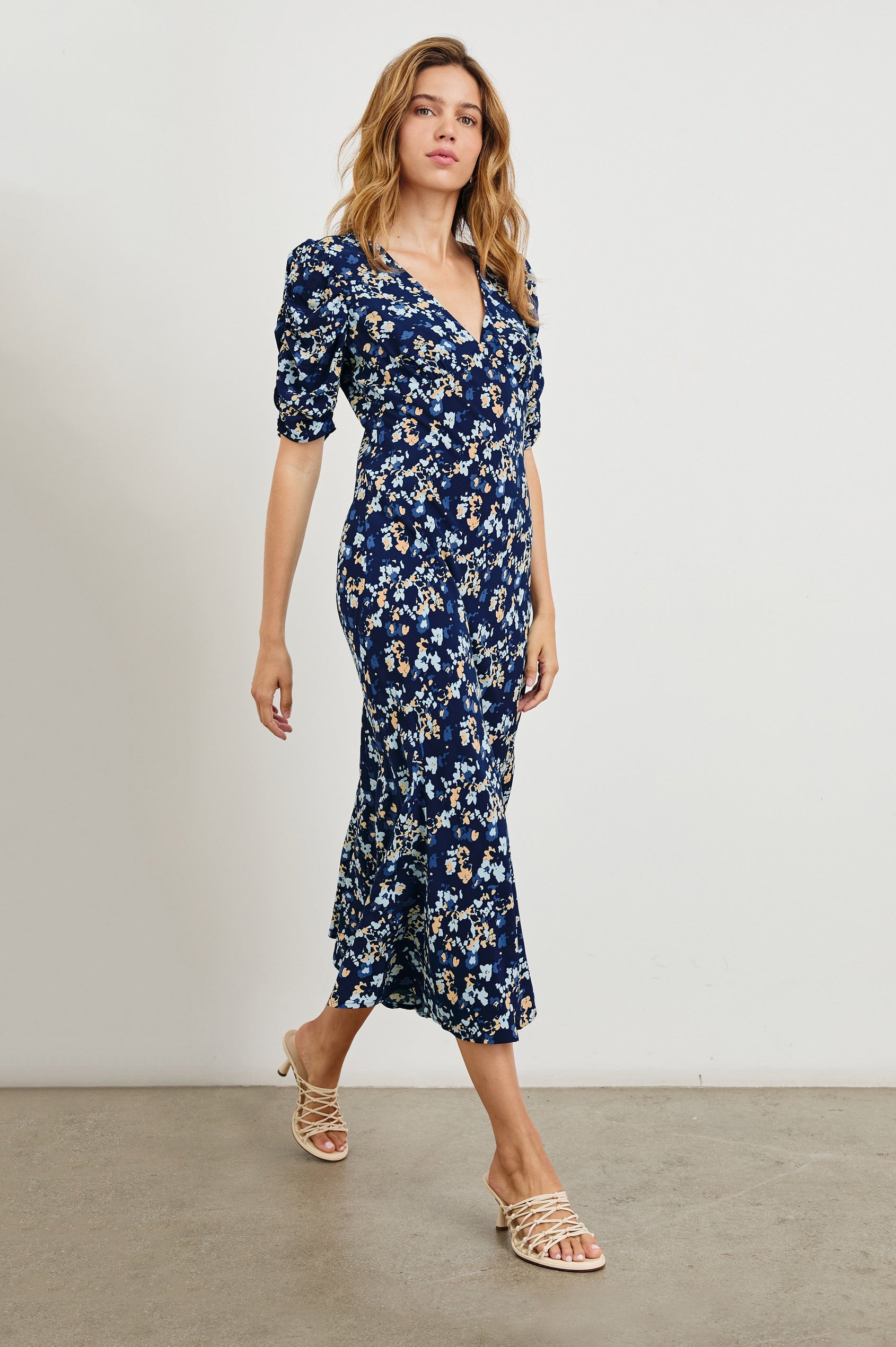 Zariah Midi Dress with Mid-Length Sleeves with Light Ruching, a Deep V Neck and an Empire Waist in Navy Flora Colorway, flowers in orange and blues on Navy - Front Full Body View Featured on Model