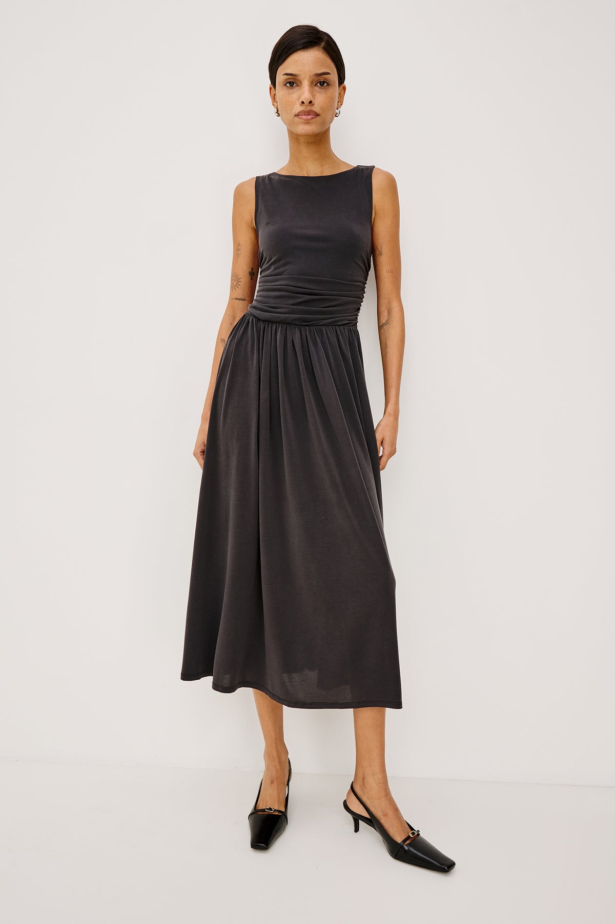 Zora Maxi Dress in Peached Jersey With Fitted Ruched Bodice, Shirred A-Line Skirt, Sleeveless Cut, and Crew Neckline in Ash Colorway - Full Body Front View Featured on Model