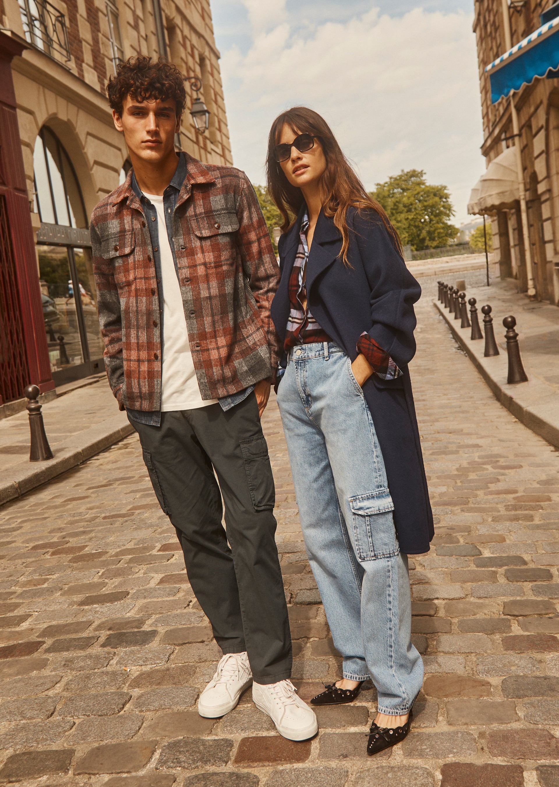 FULL BODY EDITORIAL IMAGE OF TWO MODELS. FIRST MODEL IS WEARING VIGGO SHIRT JACKET AND EMMERSON PANT. SECOND MODEL IS WEARING MARTA COAT, HUNTER SHIRT, AND SPEEDWAY CARGO PANT. 