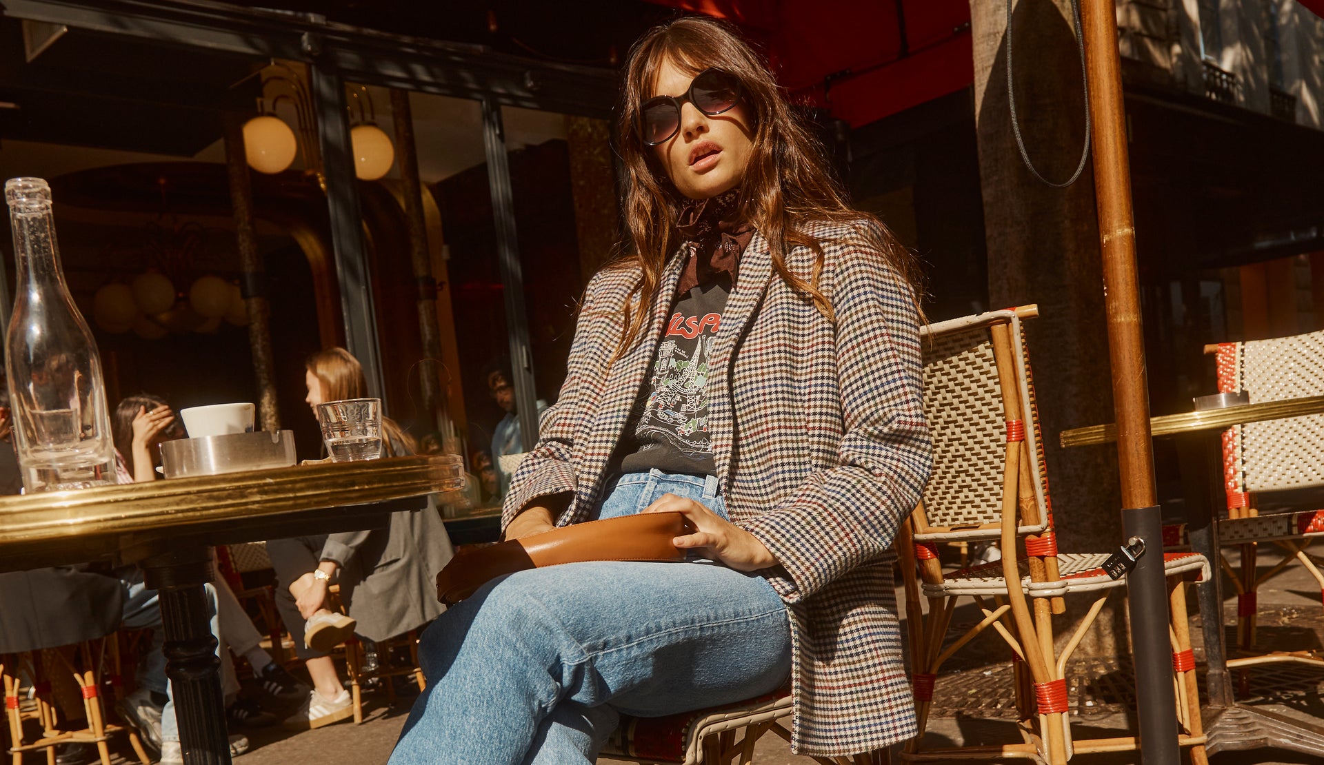 EDITORIAL IMAGE OF MODEL SITTING AT CAFE WEARING JAC BLAZER, BOYFRIEND TEE, AND TOPANGA STRAIGHT JEAN. 