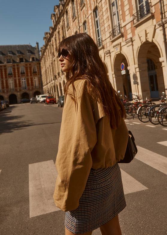 SIDE EDITORIAL IMAGE OF MODEL WEARING NORTH JACKET AND PRIM SKIRT. 