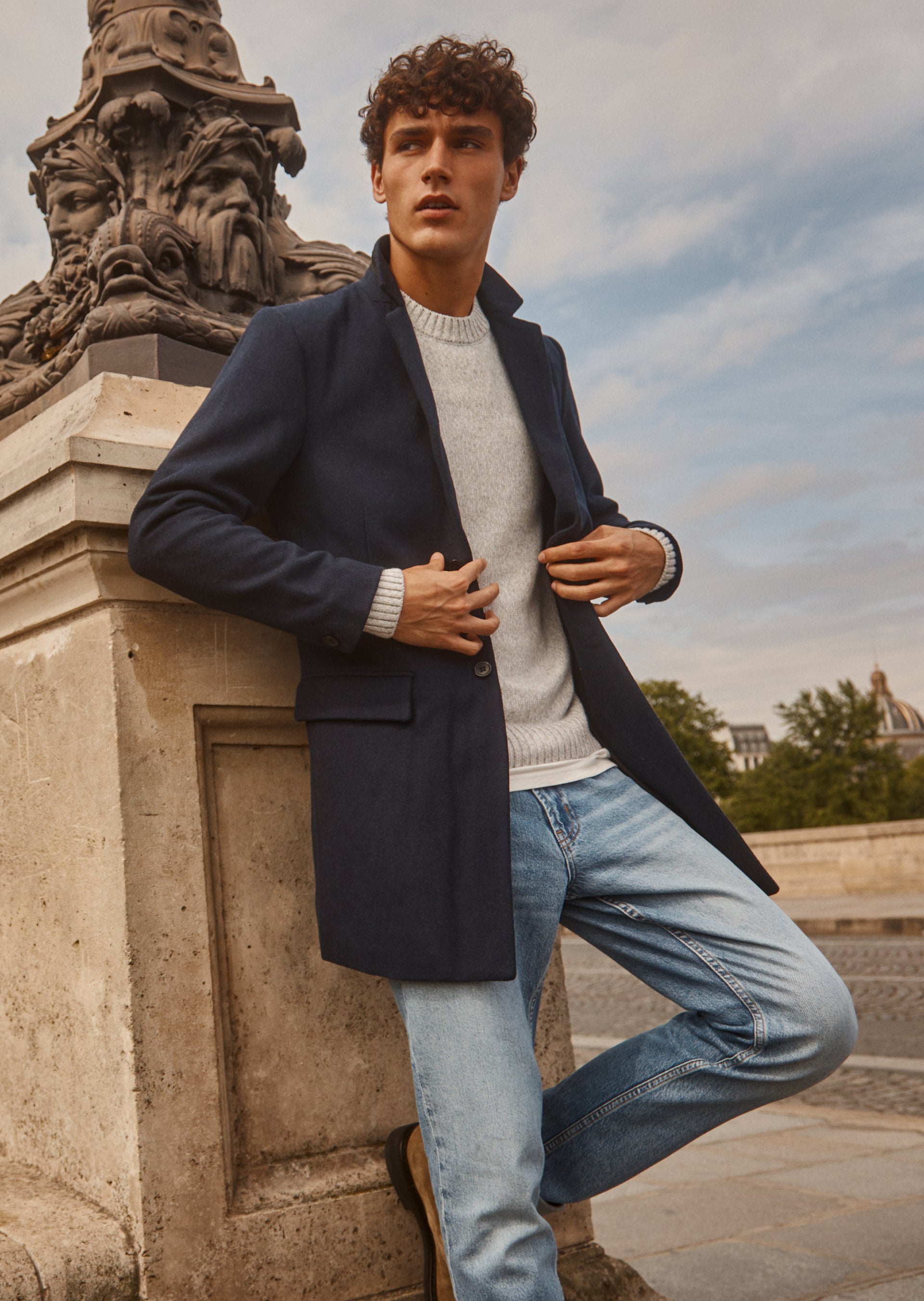 FULL BODY EDITORIAL IMAGE OF MODEL WEARING LARK COAT, DONOVAN SWEATER, AND CLAYTON SLIM STRAIGHT JEAN