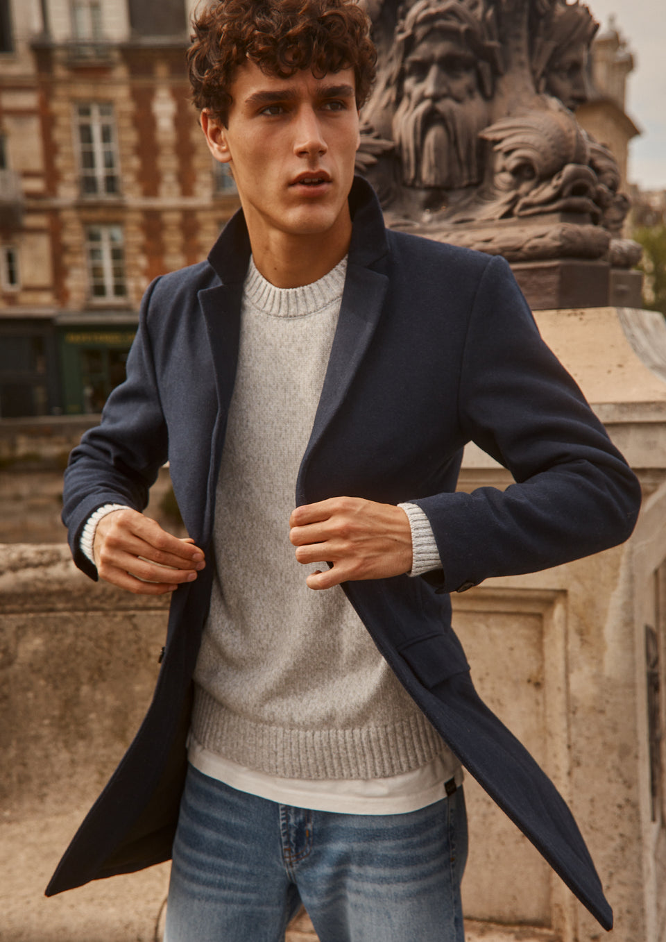 FRONT EDITORIAL IMAGE OF MODEL WEARING LARK COAT, DONOVAN SWEATER, AND CLAYTON SLIM STRAIGHT JEANS
