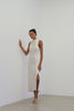 Model wearing the Solana Dress in Ivory, a midi length dress with a side sliit