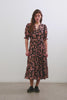 Eliana Midi Dress with Elbow-Length Sleeves with Shirred Cuffs, a V Neck, Buttons Down the Bodice, a Fabric Tie at the Waist and a Tiered Skirt in Jasmine Colorway, a Floral Pattern in Pink and Brown on Black - Back Full Body View Featured on Model