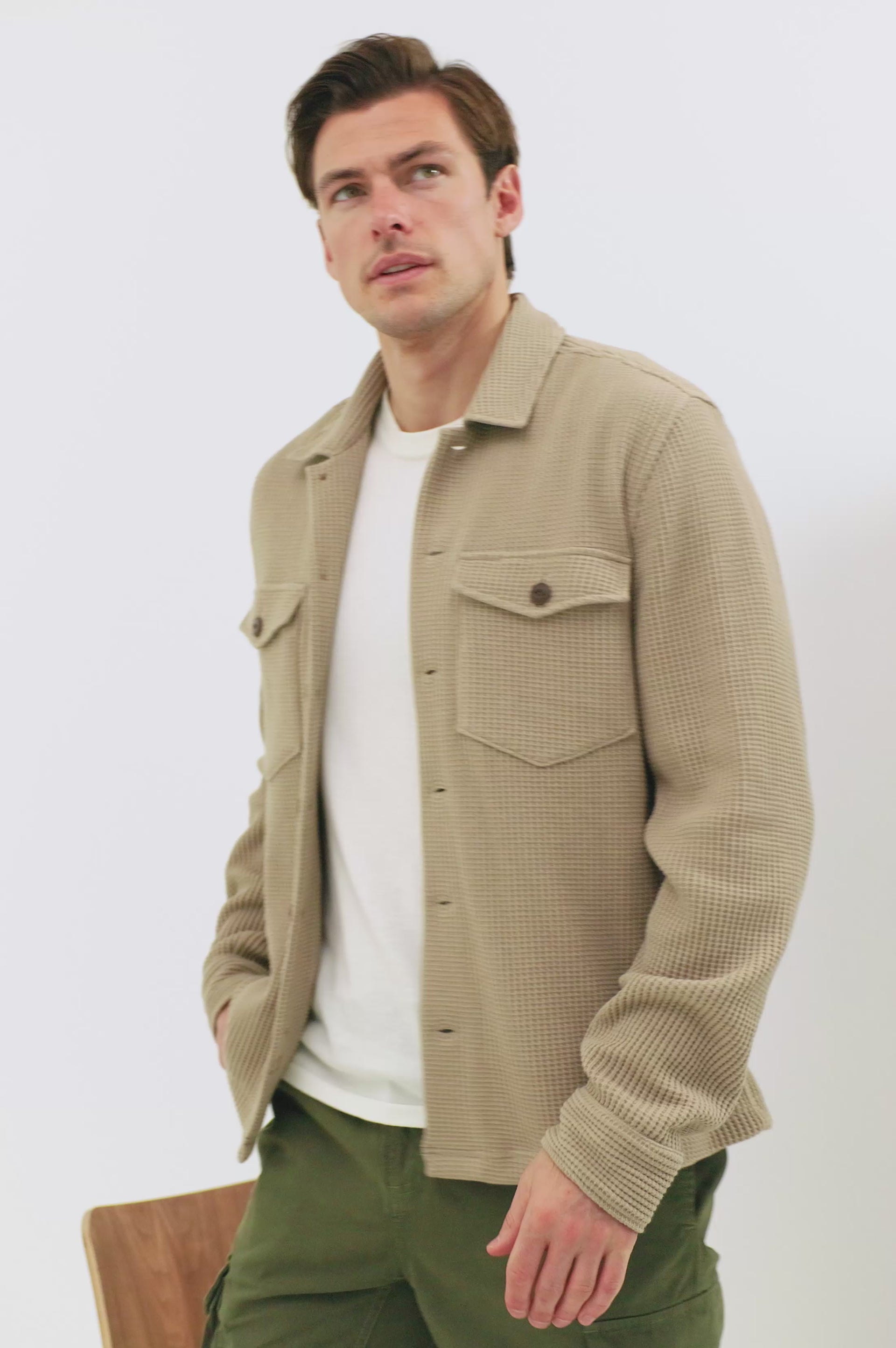 The Wells is a collared button front shirt jacket with contrast brown buttons and two chest pockets in Barley colorway. Full body walking video shown on model.