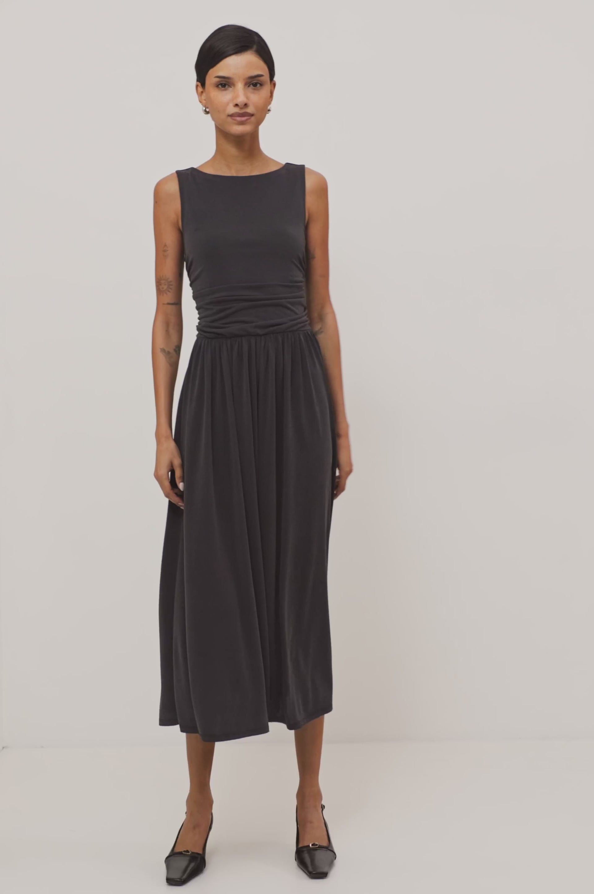 Zora Maxi Dress in Peached Jersey With Fitted Ruched Bodice, Shirred A-Line Skirt, Sleeveless Cut, and Crew Neckline in Ash Colorway - Full Body Front View Featured on Model - Video