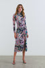 (Video): Mona Dress in Midnight Verbena shown on a model to showcase the floral print, mesh material, high collar, adjustable ruching, and open leg slit. Full Body View Featured on Model.