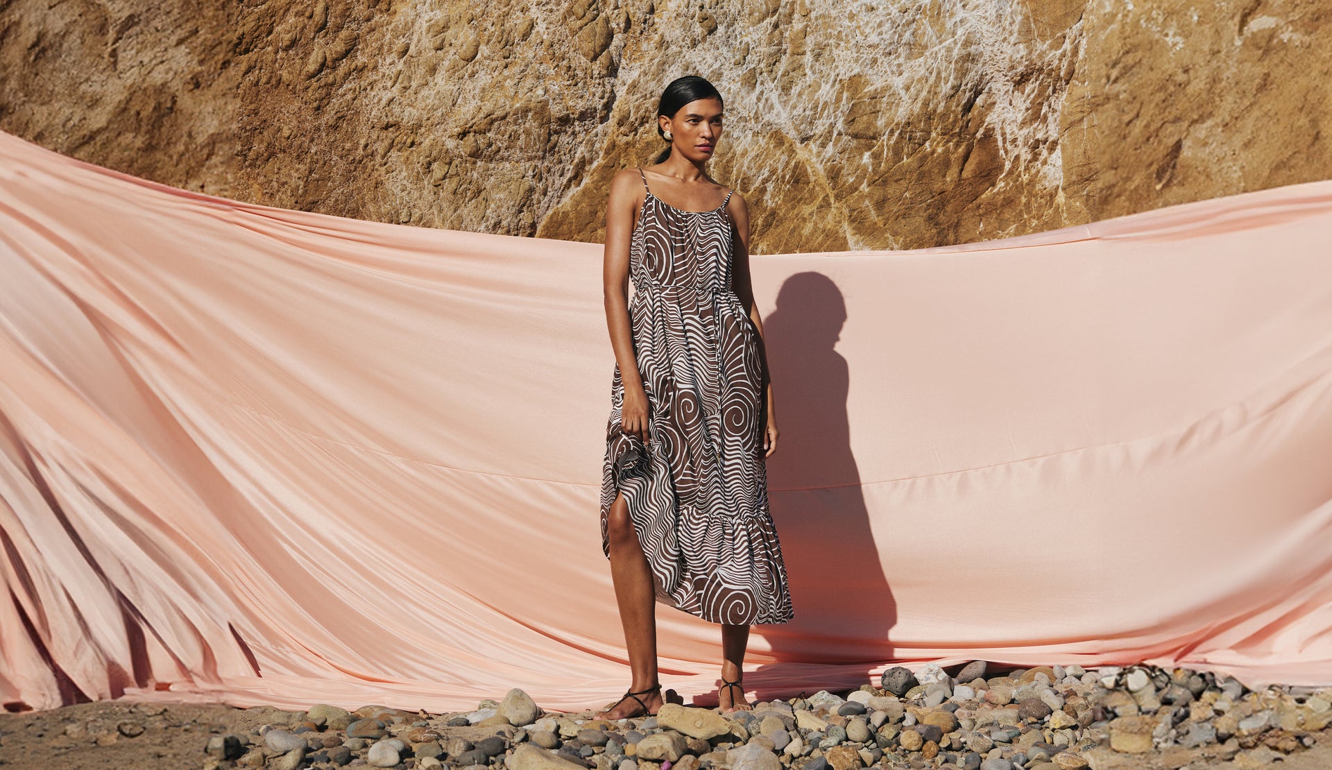 FRONT FULL BODY EDITORIAL IMAGE OF MODEL ON THE BEACH WEARING MARIS DRESS IN SWIRLS