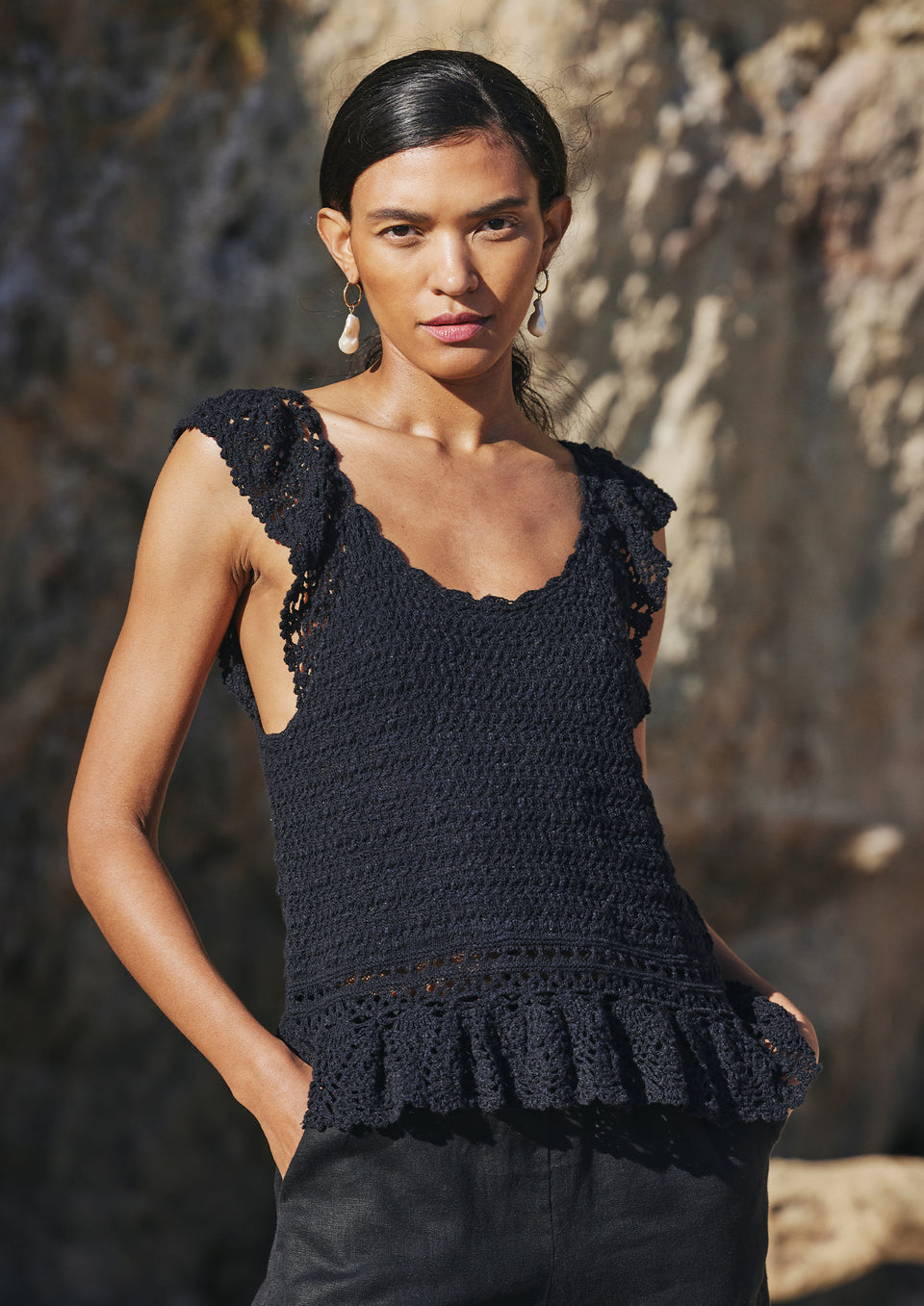 FRONT EDITORIAL IMAGE OF MODEL ON THE BEACH WEARING HATTIE TOP IN BLACK