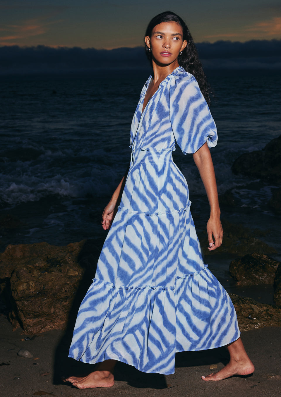 SIDE FULL BODY EDITORIAL IMAGE OF MODEL WEARING CATERINE DRESS IN BLUE WATERCOLOR STRIPES