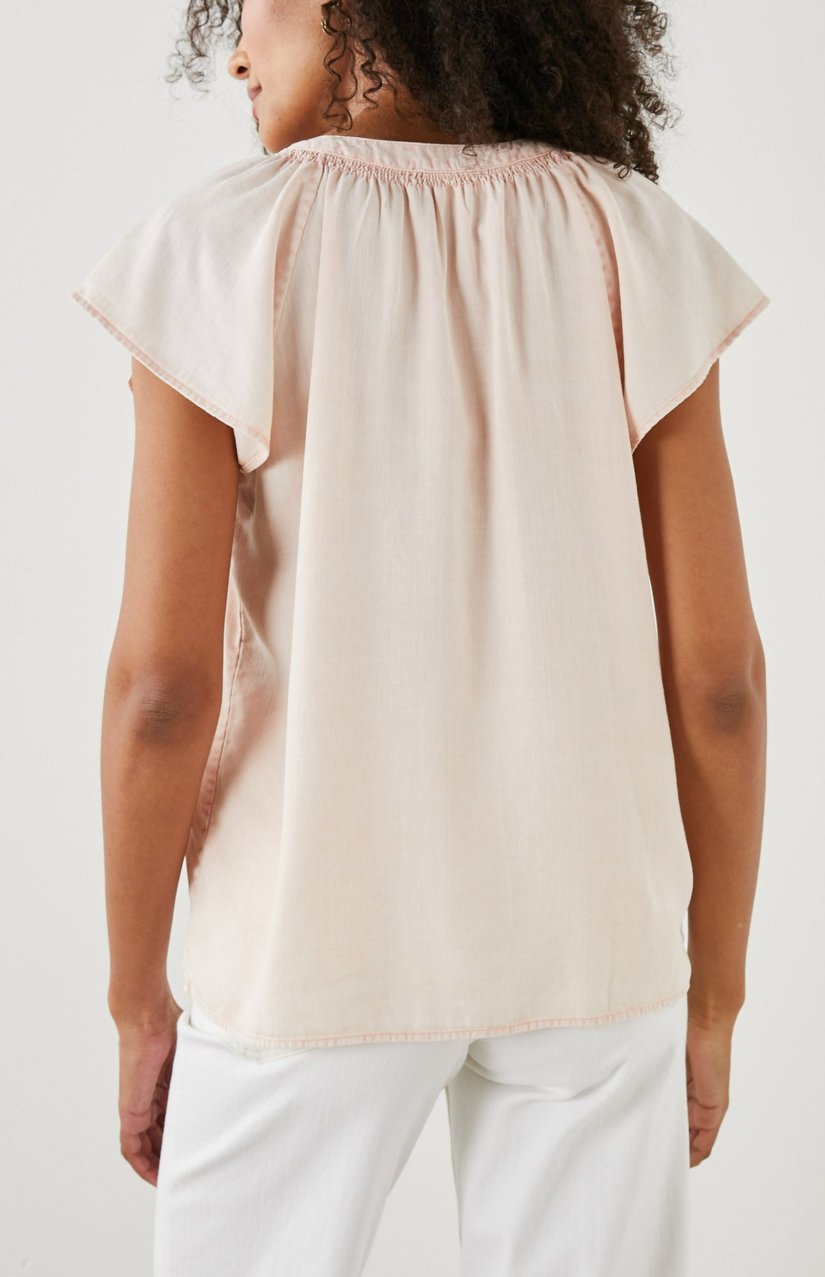 Alena Short Sleeve Top with Flutter Sleeves, a V Neck, Buttons Down the Bodice and Ruching along the Collar in Petal Colorway - Back View Featured on Model