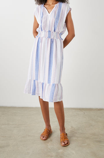 Ashlyn Short Sleeve Midi Dress with a V neck with Ties, a Smocked Waist and a Ruffle Tier at the Hem in Marini Stripe Colorway, Vertical Stripes in Pink and Blue on White - Front Full Body View Featured on Model
