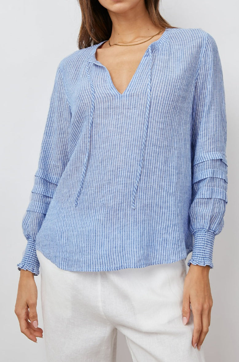 Caterina Long-Sleeve Top with a V neck, Neck Ties, Shirred Cuffs and Horizontal Pleats on the Sleeves in Sanibel Stripe Colorway, Thin White and Blue Vertical Stripes - Front View Featured on Model