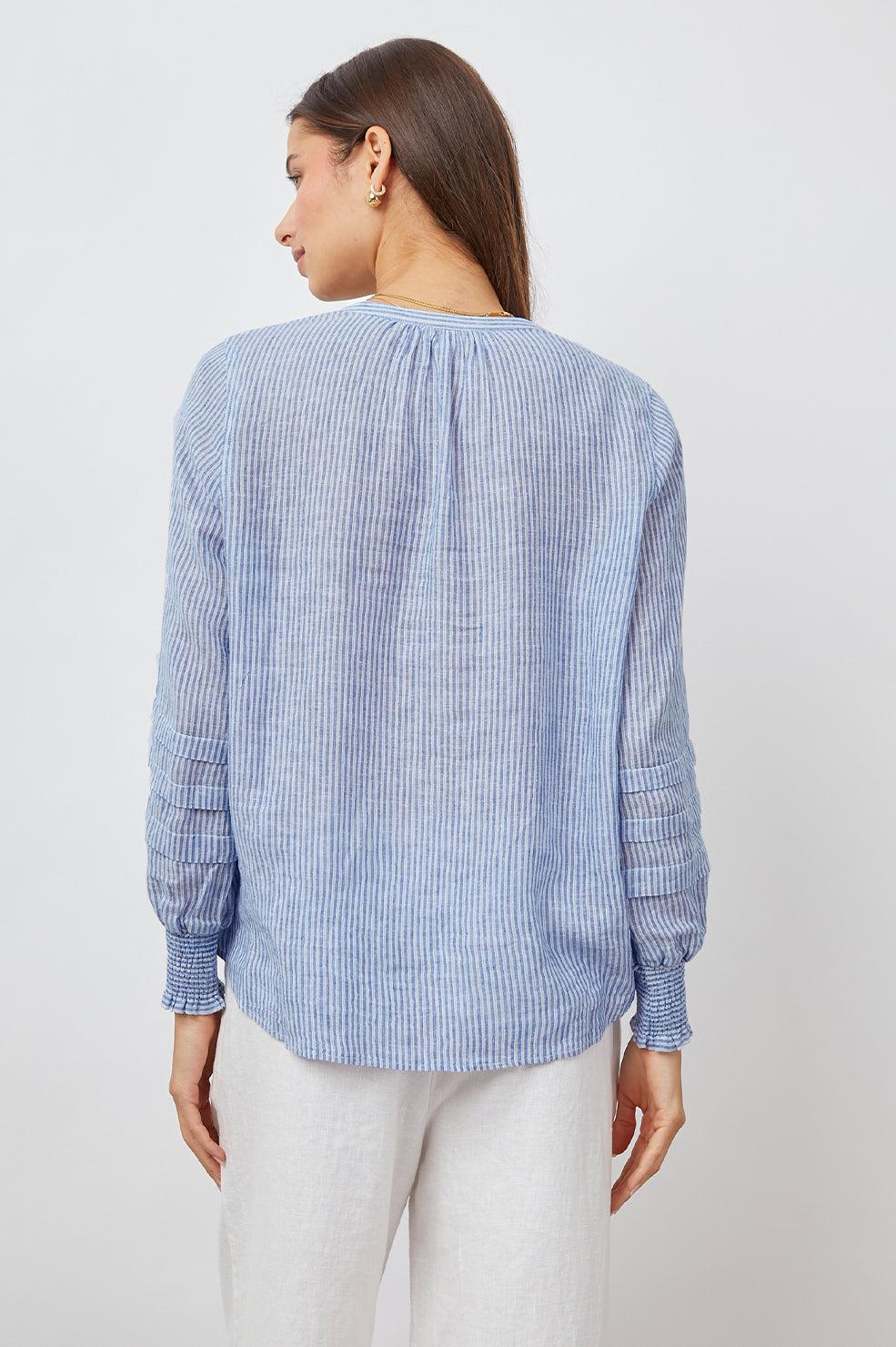 Caterina Long-Sleeve Top with a V neck, Neck Ties, Shirred Cuffs and Horizontal Pleats on the Sleeves in Sanibel Stripe Colorway, Thin White and Blue Vertical Stripes - Back View Featured on Model