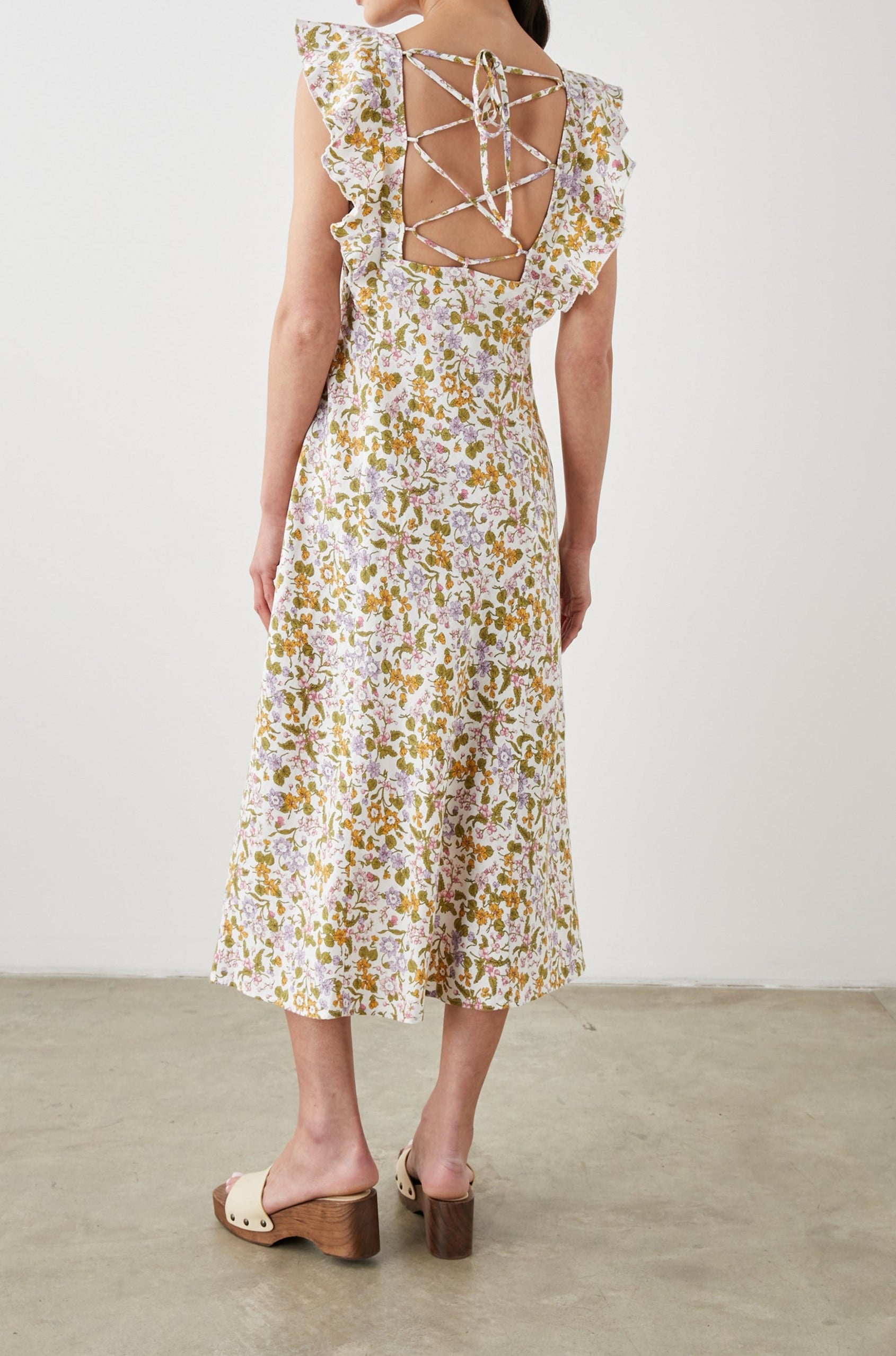 Constance Short Sleeve Midi Dress with Flutter Sleeves, a V Neck, and Cross Ties Across the Mid to Upper Back in Tansy Colorway, Brown, Orange, Purple, Pink and Green on White - Back Full Body View Featured on Model 