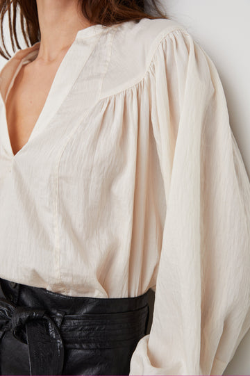 Fable Long Sleeve Top with a V Neck with a Placket, Buttoned Cuffs, and Pleating Down From the Yoke in Lotus Colorway - Front Tucked View Featured on Model 