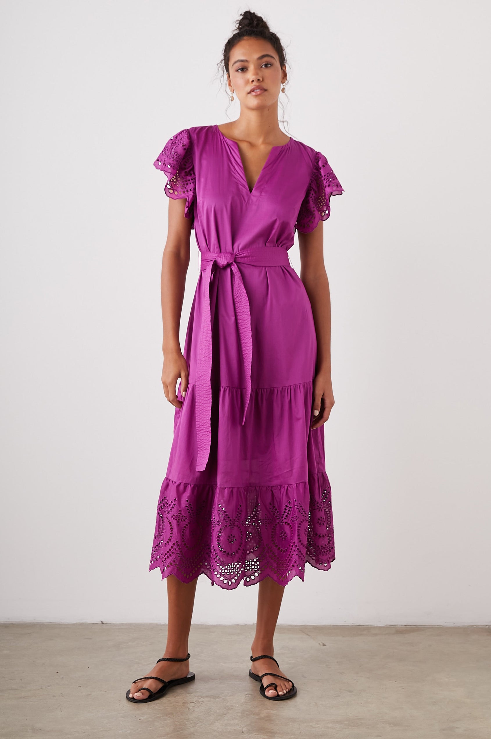 Gia Short-Sleeve Midi Dress with Flutter Sleeves, a V Neck, a Fabric Tie at the Waist, a Tiered Skirt and Eyelet Detail on the Sleeves and Hem in Berry Colorway - Front Full Body View Featured on Model
