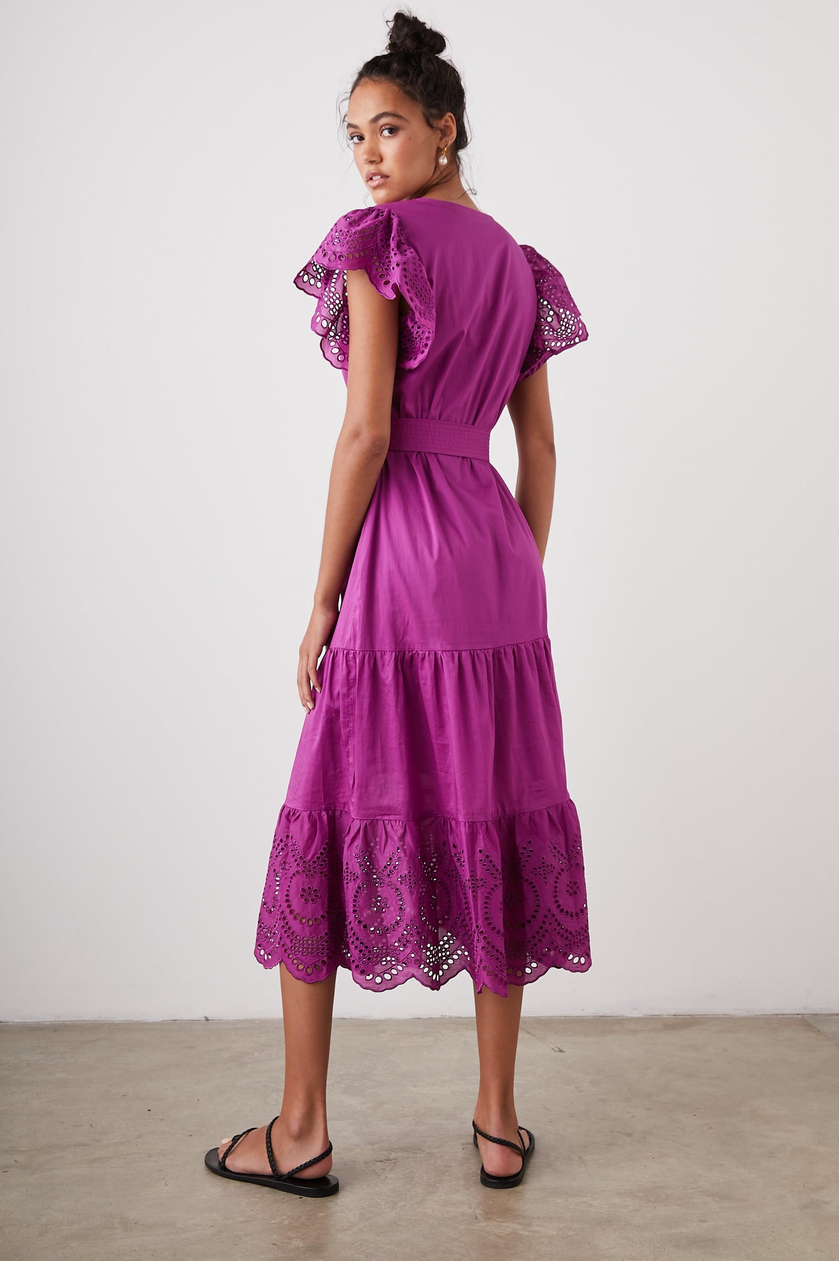 Gia Short-Sleeve Midi Dress with Flutter Sleeves, a V Neck, a Fabric Tie at the Waist, a Tiered Skirt and Eyelet Detail on the Sleeves and Hem in Berry Colorway - Back Full Body View Featured on Model