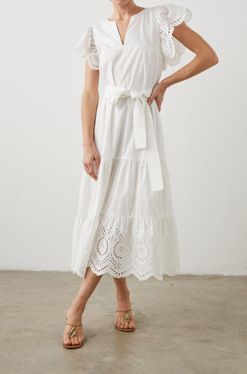 Gia Short-Sleeve Midi Dress with Flutter Sleeves, a V Neck, a Fabric Tie at the Waist, a Tiered Skirt and Eyelet Detail on the Sleeves and Hem in White Colorway - Front Full Body View Featured on Model