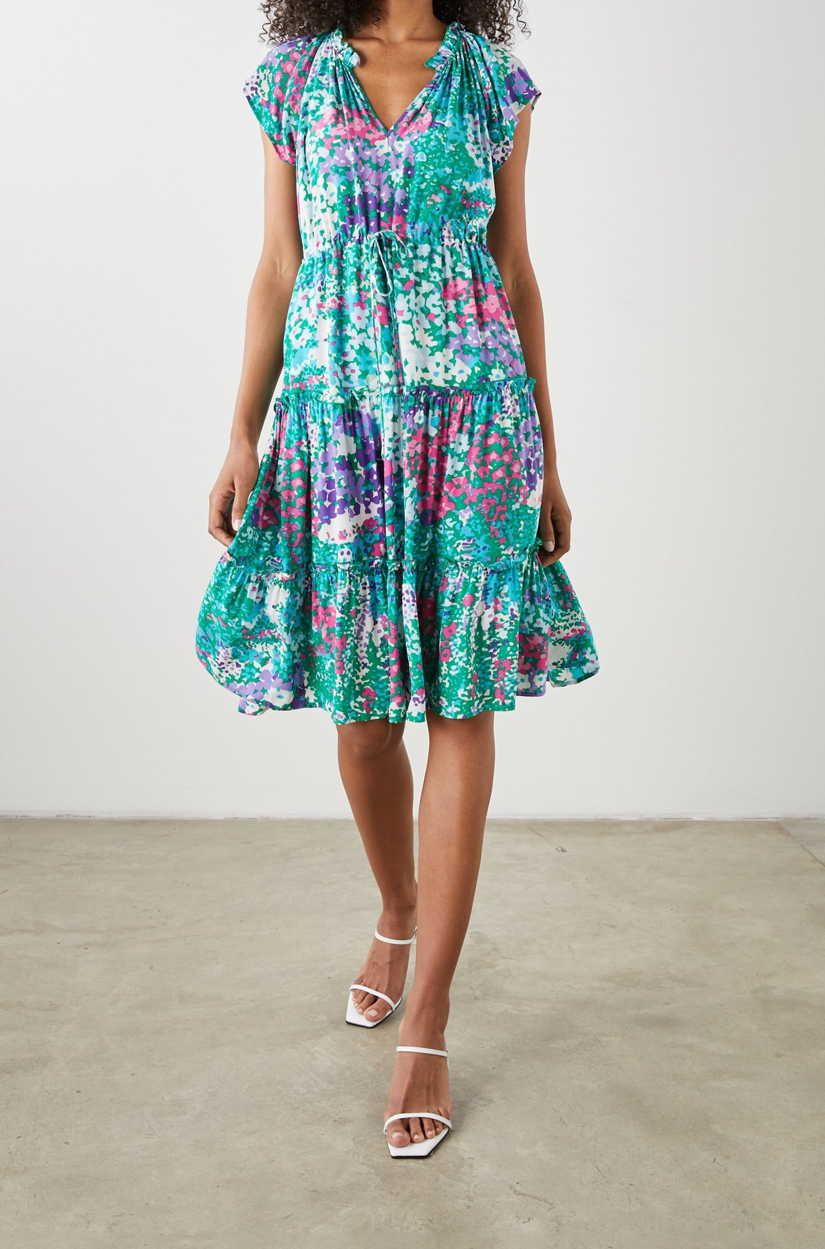 Juni Short Sleeve Midi Dress with a V Neck, Light Ruching along the Neckline, a Drawstring Waist, and a Tiered Skirt in Gardenia Floral Colorway, in Greens, Blues, Purples, Pinks and White - Front View Featured on Model