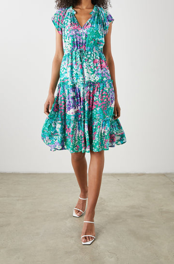 Juni Short Sleeve Midi Dress with a V Neck, Light Ruching along the Neckline, a Drawstring Waist, and a Tiered Skirt in Gardenia Floral Colorway, in Greens, Blues, Purples, Pinks and White - Front View Featured on Model
