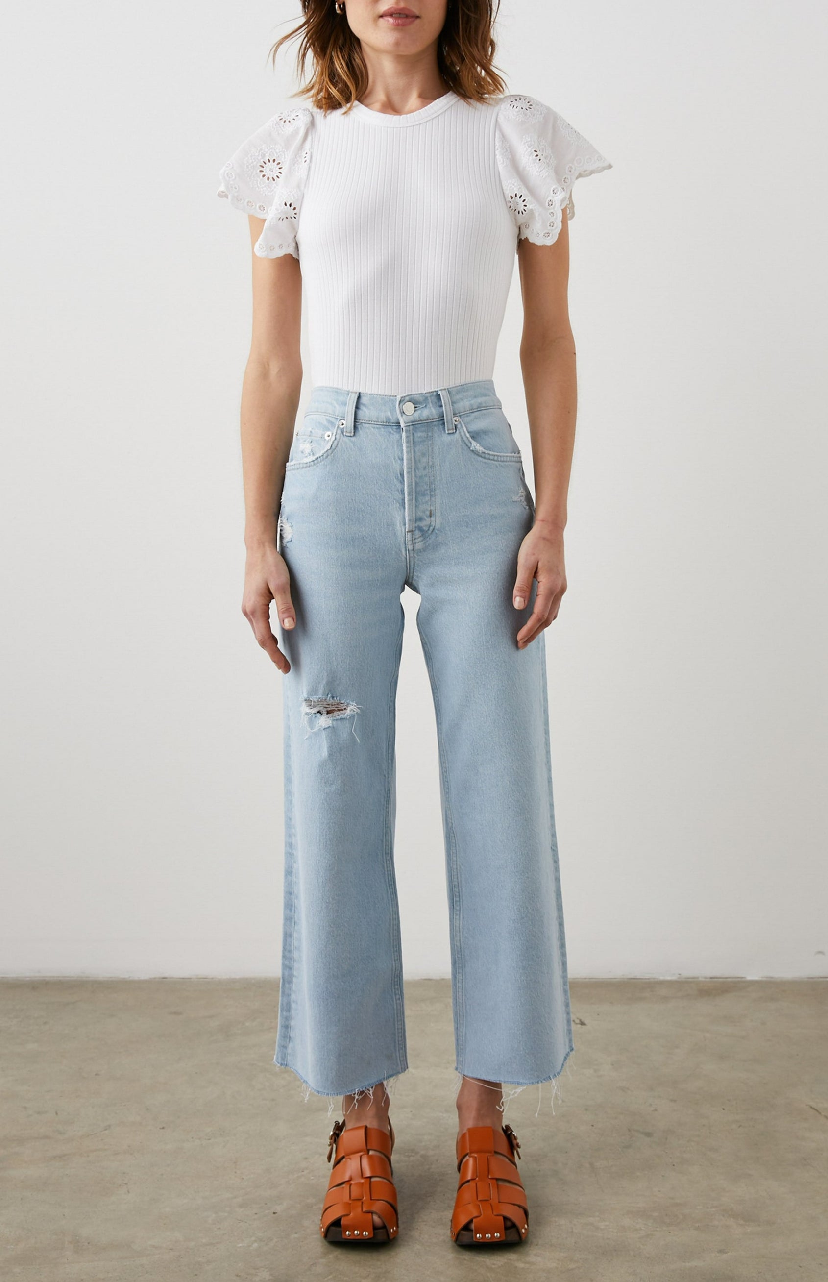 Reza Ribbed Short Sleeve Top with Flutter Sleeves, a Crew Neck and Floral Eyelets on the Sleeves in White Colorway - Front Tucked Full Body View Featured on Model 