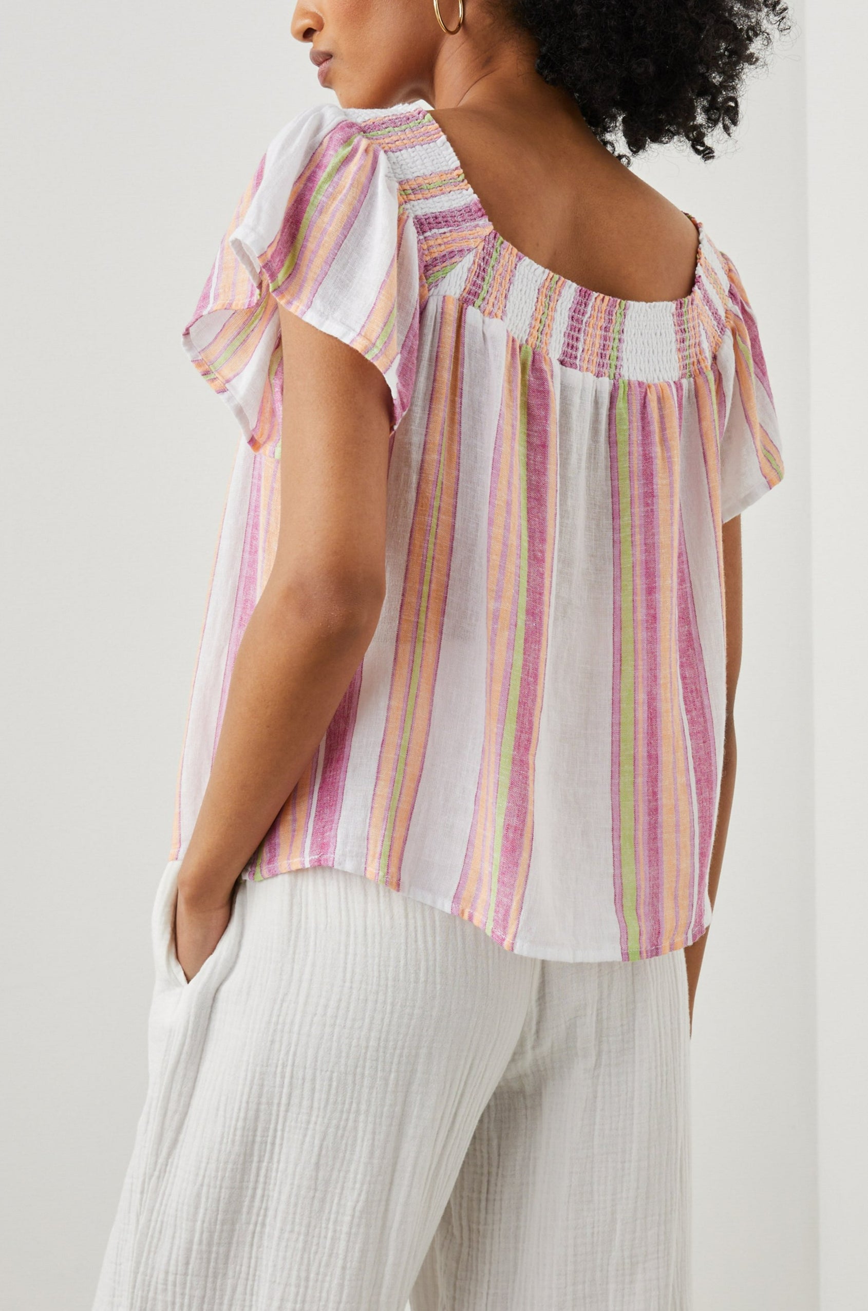 Sonora Short Sleeve Top with a Scoop Neckline and Shirring at the Neckline in Hibiscus Stripe Colorway, Vertical Stripes in Green, Orange, Pink and White - Back View Featured on Model 