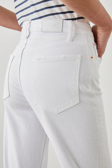 Topanga Straight Jeans with a Hole at the Knee and Fraying, Belt Loops, Two Front Pockets plus a Coin Pocket and Two Back Patch Pockets in Salt White Distress Colorway - Back View Featured on Model