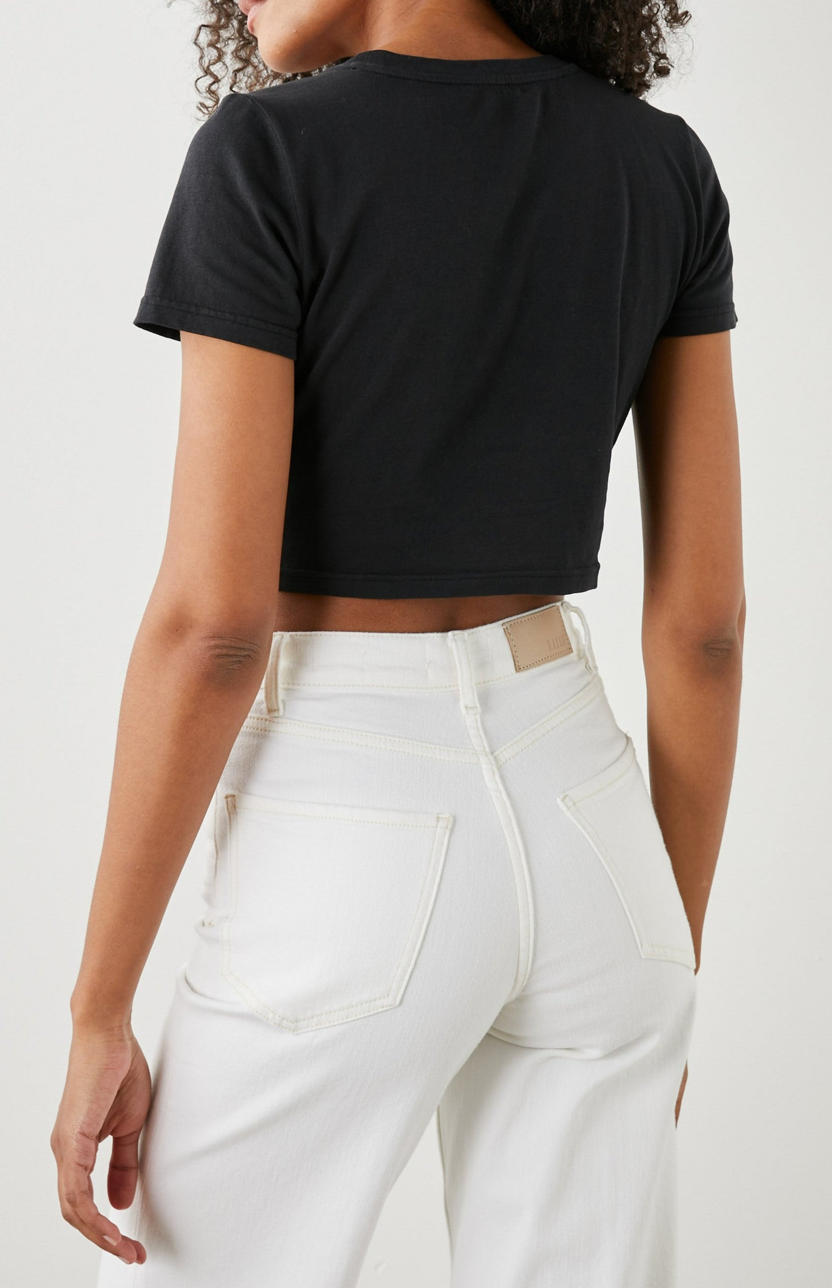 Zena Short-Sleeve Cropped T-Shirt with a Crew Neck and a Circular Cutout with a Tie at the Front Hem in Black Colorway - Back View Featured on Model 